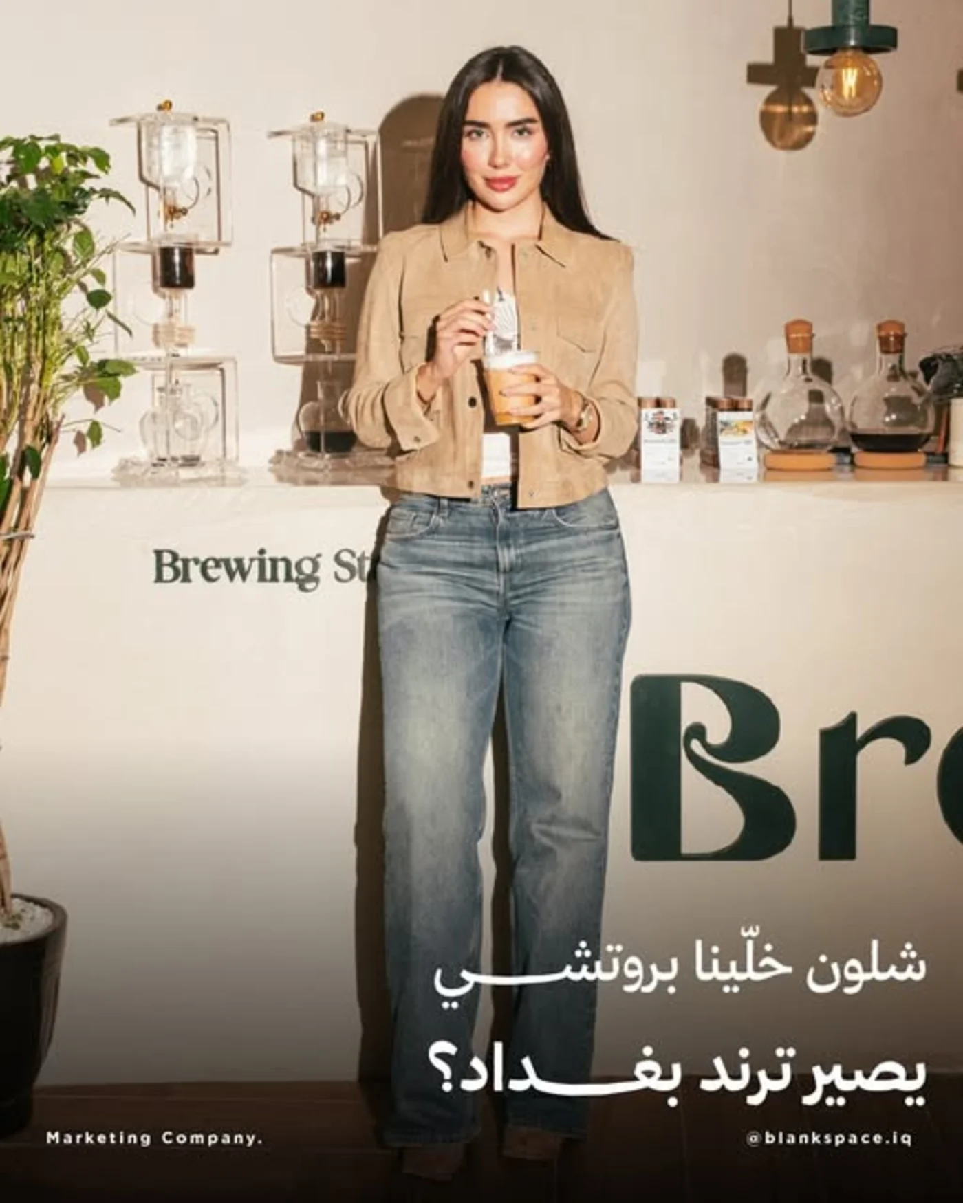 امرأة تقف بجانب معدات تحضير القهوة في حملة السوشيال لعلامة Brotish للقهوة في بغداد
